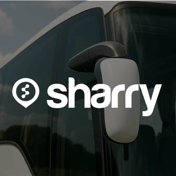 логотип і назва компанії Sharry на фоні бокового дзеркала заднього виду автобуса